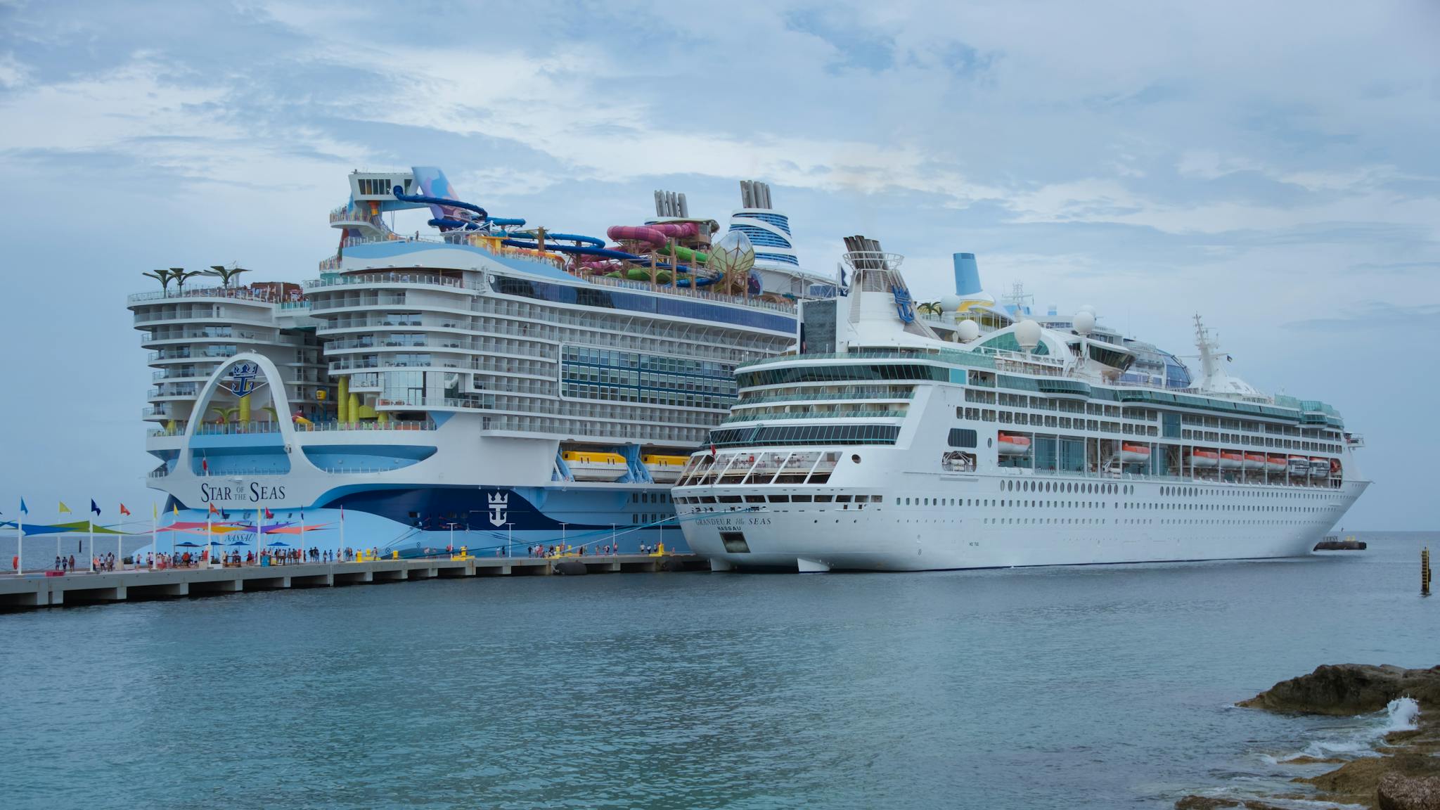 Two luxurious cruise ships docked at a lively port in the Bahamas, capturing the essence of tropical travel.
